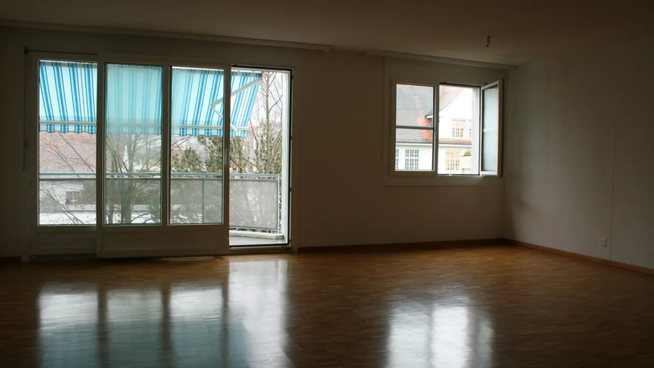 Balkon kapıları açık, eşyasız bir oda